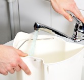 De afvalwatercontainer bijvullen met vers water
