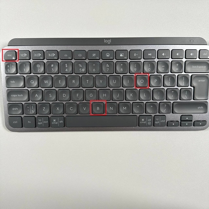 Vingers drukken op de Escape-, O-, Escape- en B-toetsen op de MX Keys Mini