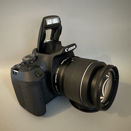 Op de flitsknop drukken op een Canon-camera