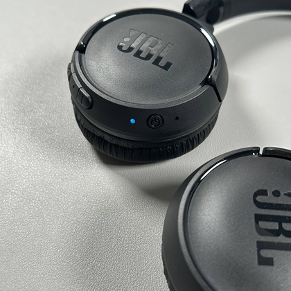 De aan/uit-knop van de JBL Tune 520BT ingedrukt houden